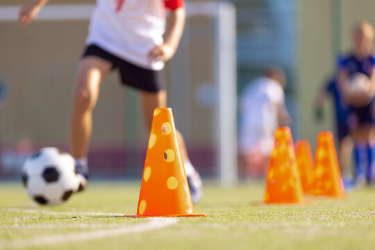 Outdoor Soccer Training Session. Players Dribbling Football Balls Between Line of Training Cones. Football Club Practice Field For Youth Teams
