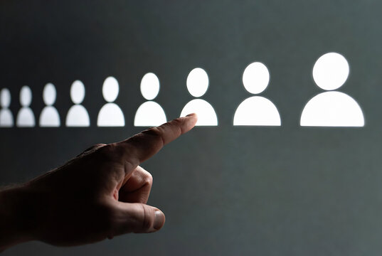 A hand is touching a digital screen displaying silhouettes of people, representing user selection or profile management. It&rsquo;s likely a social media or online platform interface.