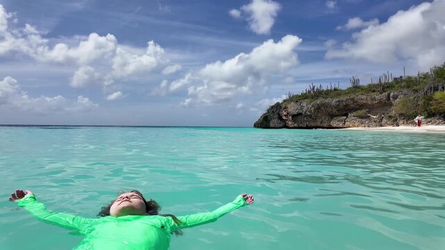 Child enjoys summer swim in tropical lagoon. Summer vacation with kid swimming in ocean. Child feels summer freedom in sea. Kid plays and swim in sea in summer.