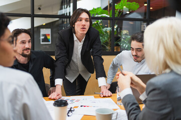 Fototapeta premium Teamwork brainstorm. Coworkers cooperating working together at office meeting. Colleagues discussing project ideas. Group of people in creative office discussing business. Young professional team