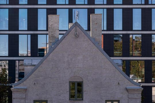Oslo urban cityscape presents gable roof facade in contrast with modern office architecture blending residential and corporate forms in dense blocks
