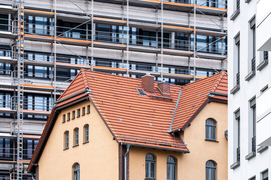 Berlin urban cityscape shows house and construction scaffold with modern architecture contrast highlighting development in evolving neighborhood