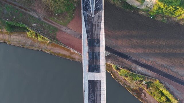 Aerial drone shot flying backward and tilting up from a top-down view of the Keel Crossing to reveal Keel Square and the modern city skyline of Sunderland at sunrise.
