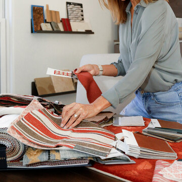 Interior designer selecting fabric samples at worktable