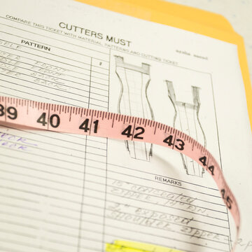 Measuring tape over fashion pattern sheet