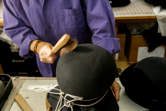 Milliner shaping felt hat by hand
