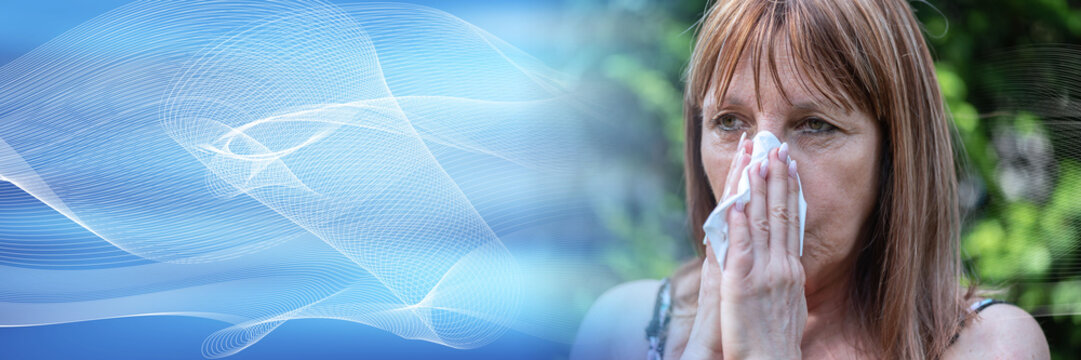 Mature woman blowing her nose; panoramic banner