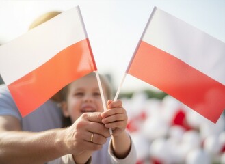 Obraz premium Rodzic i dziecko trzymające wspólnie flagę Polski. Tło rozmyte (bokeh), biało-czerwone barwy dominują. Zdjęcie symbolizujące patriotyzm i święto narodowe, czyste i jasne.