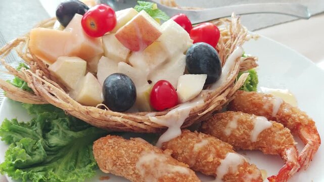 Fruit salad in a fried taro basket with shrimp.