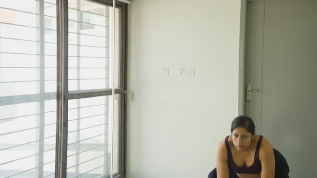 Pregnant Indian woman taking care of her body lifting weights during third trimester pregnancy