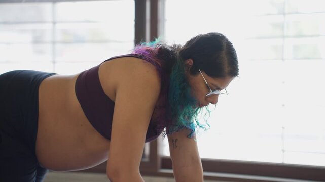 Third trimester young Indian female does yoga balance exercise routine in deep concentration
