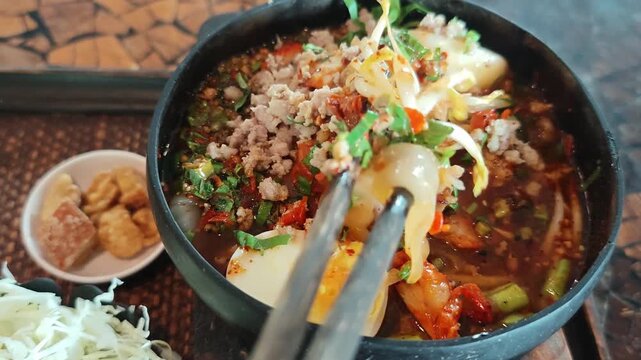 Pork noodle soup with meatballs served in a coconut shell bowl is a Thai dish.Noodle soup in a coconut shell bowl