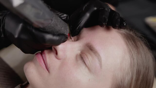 Closeup of inter-eyelash tattoo microblading process on female brow, permanent cosmetic procedure.