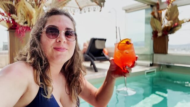 A Stylish Young Woman Enjoying a Drink at a Luxury Rooftop Pool on a Sunny Day