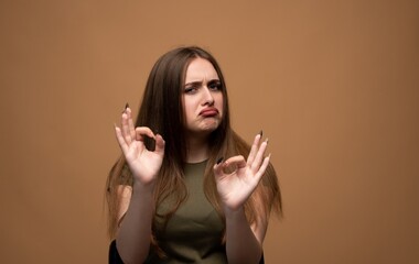 Woman making sarcastic ok gesture with frowning face, expressing disapproval and mock appreciation © Volodymyr_sh