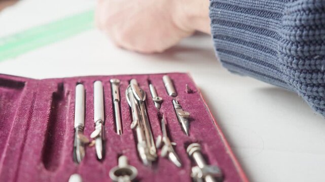 Hands reveal a refined set of drafting tools in a velvet box, conveying precision, craftsmanship, and focused design work. Ideal for architecture, engineering, and creative process storytelling.