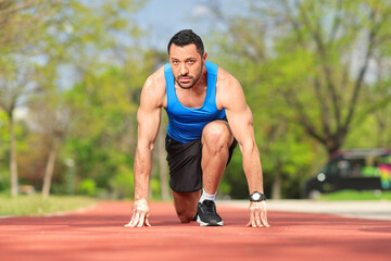 Obraz premium Muscular man in start position for running