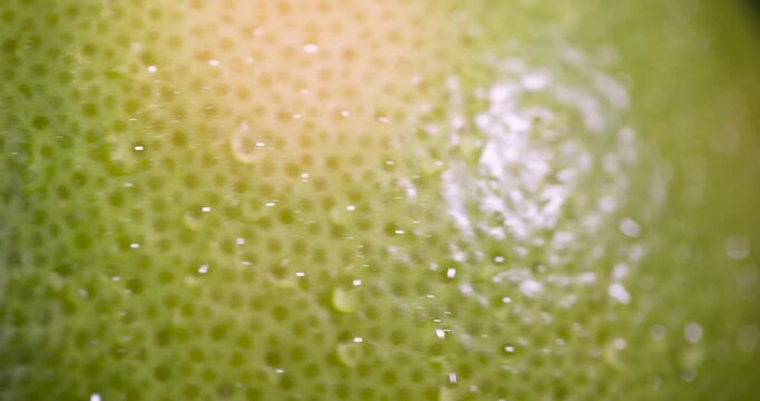 a wet yellow-green grapefruit on the table, one large grapefruit with a peel of different colors is covered with drops of clear water, beauty product