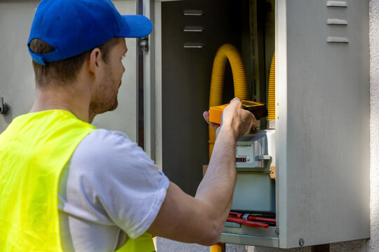 Technician checking natural gas leak with detector in meter box. Gas maintenance and repair service