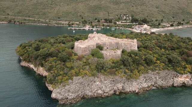 Aerial zoom out view Porto Palermo Castle on hilltop. Ali Pasha unique triangular fortress on Albania coastline.