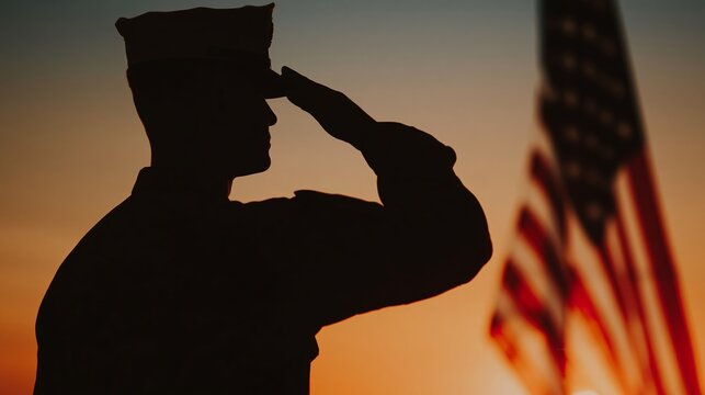 Silhouette of soldier saluting at sunset with flag in background, US Memorial Day