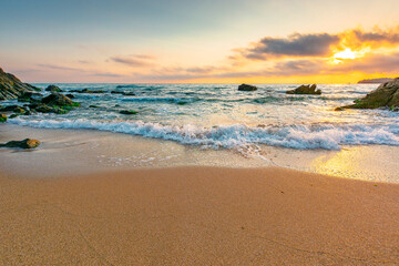 Obraz premium sandy beach of a black sea at sunrise. bulgaria scene on hot summer vacation season. beautiful view of waves washing the sand in morning light. generic image of seascape and sky for background