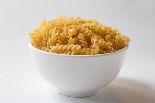 fusilli pasta in a bowl on a white background
