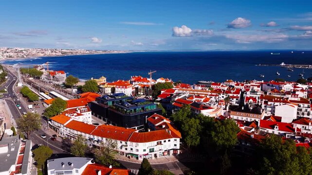 Orbiting shot of Cascais downtown, and marina with boats under clear blue sky. Cascais, Portugal