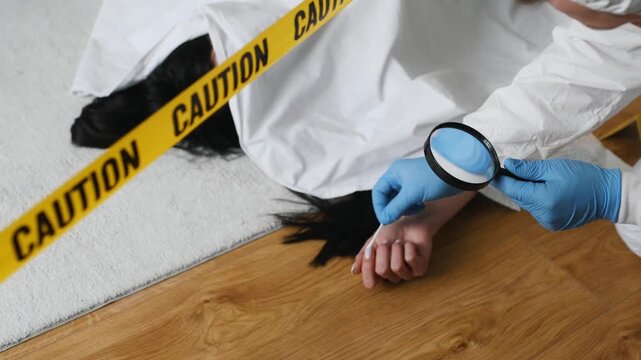 Forensic expert in protective gear examines evidence at a murder scene with a body covered in a white sheet and caution tape marking the area