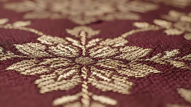 Closeup Macro Shot of Intricate Gold Floral Embroidery on Deep Red Fabric.
