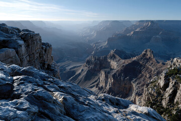 Fototapeta premium This breathtaking view of a vast canyon at dusk showcases intricate rock formations and serene atmosphere crafted by nature's erosion over millions of years.