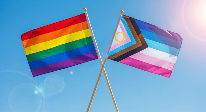 Two crossed flags against blue sky: rainbow flag and progress pride flag, representing inclusivity and support, ideal for tolerance and diversity concepts