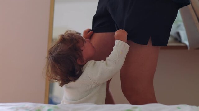 Toddler reaching up to mother asking for attention and comfort before being picked up showing attachment need trust and emotional bonding in everyday parenting moment at home