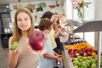 Fototapeta premium School cafeteria with students choosing fresh fruits from a colorful selection