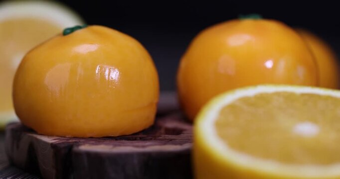sweet calorie cake that simulates an orange is lying on the table, an orange sweet cake with orange flavor and orange pulp, food styling