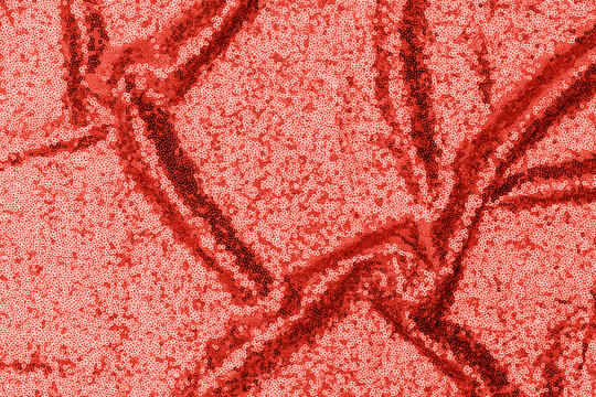 Bright red sequin fabric with a wavy pattern shines under light in an indoor setting during daytime