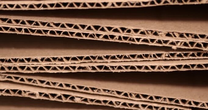 Recycled cardboard paper lies in layers, thick technical paper with a corrugated inner layer and villi on a macro cut with a clear contour and an organic surface of the paper product.