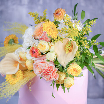 Bright flowers in a pink vase on a plain background during daylight