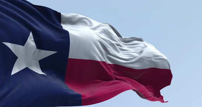 Close-up of Texas state flag waving in the wind. Blue vertical stripe with white star, white and red horizontal stripes. Seamless 3d render animation. Slow motion loop. Selective focus