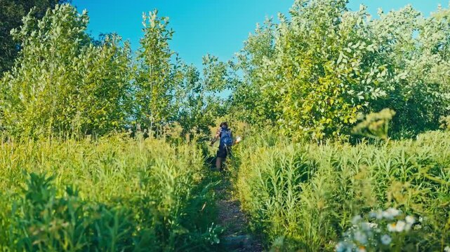 Man Using A Powered Brush Cutter To Clear Tall Vegetation And Reeds - Wide Shot