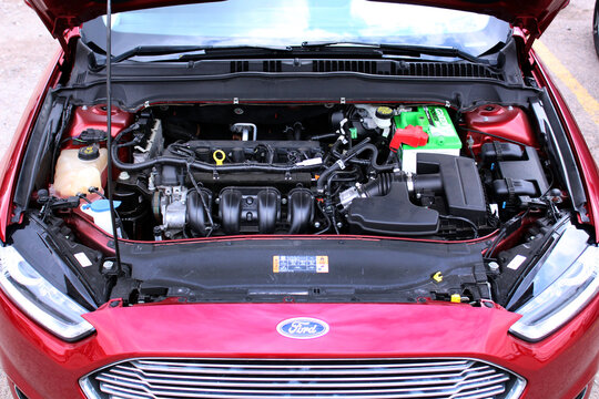 Vinnytsia, Ukraine; April 11, 2026. Close up red USA Ford Fusion open hood. USA sedan Ford Fusion 2.5 gas engine. Broken engine Ford Fusion with the hood up. Engine parts modern car. Front view.