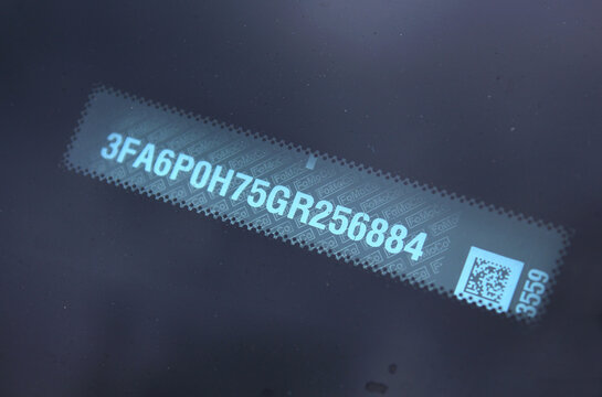 Vinnytsia, Ukraine; April 11, 2026. Close up red USA Ford Fusion VIN code. Vehicle identification number. Ford Fusion number vehicle. Ford Fusion car unique code. VIN number new electric car. Ford Fus