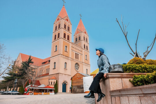 Asian women tourist with cityscape of Qingdao with St. Michael&rsquo;s Cathedral in China Shandong Province.