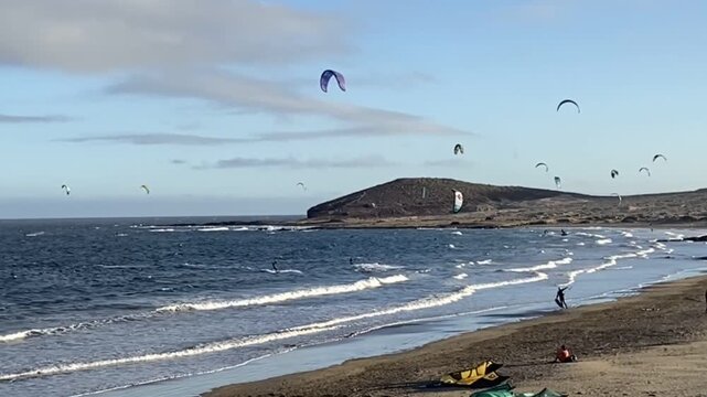 Kitesurfers on waves of Atlantic ocean in El Medano,Tenerife,Canary Islands,Spain. Kitesurfing, kiteboarding, kite surf. Extreme recreational water sport activity, summer fun adventure concept, 4K.