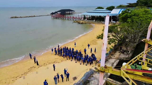 Aerial Beach Crowd Gathering Near Pier and Resort Coastline 4KView