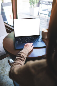 Vertical mockup image of a woman working on laptop computer with blank white desktop screen in cafe