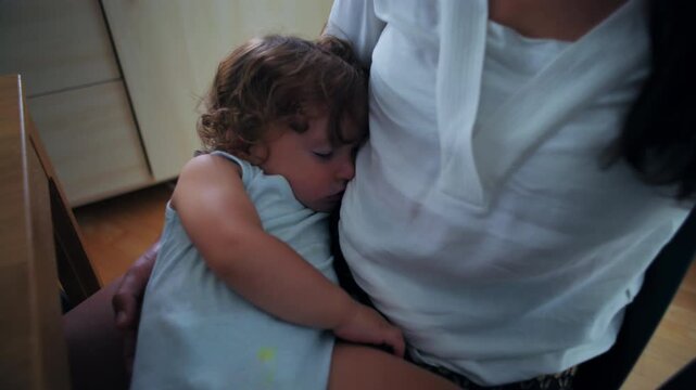 Sleeping toddler resting against mother chest in quiet moment of comfort trust and deep attachment showing peaceful connection and secure bonding in intimate home environment