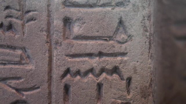 Ancient egyptian hieroglyphs carved in a stone bas-relief representing a wall painting from a tomb. Artistic representation of a pharaoh's life and historical events