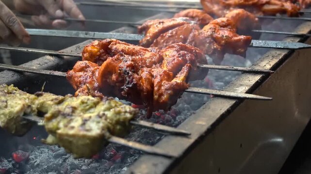 Chicken tikka and seekh kebabs grilling over smoky hot coals, bbq street food concept