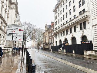 Naklejka premium Parliament Square rainy street scene in London, UK with historic architecture and pedestrians